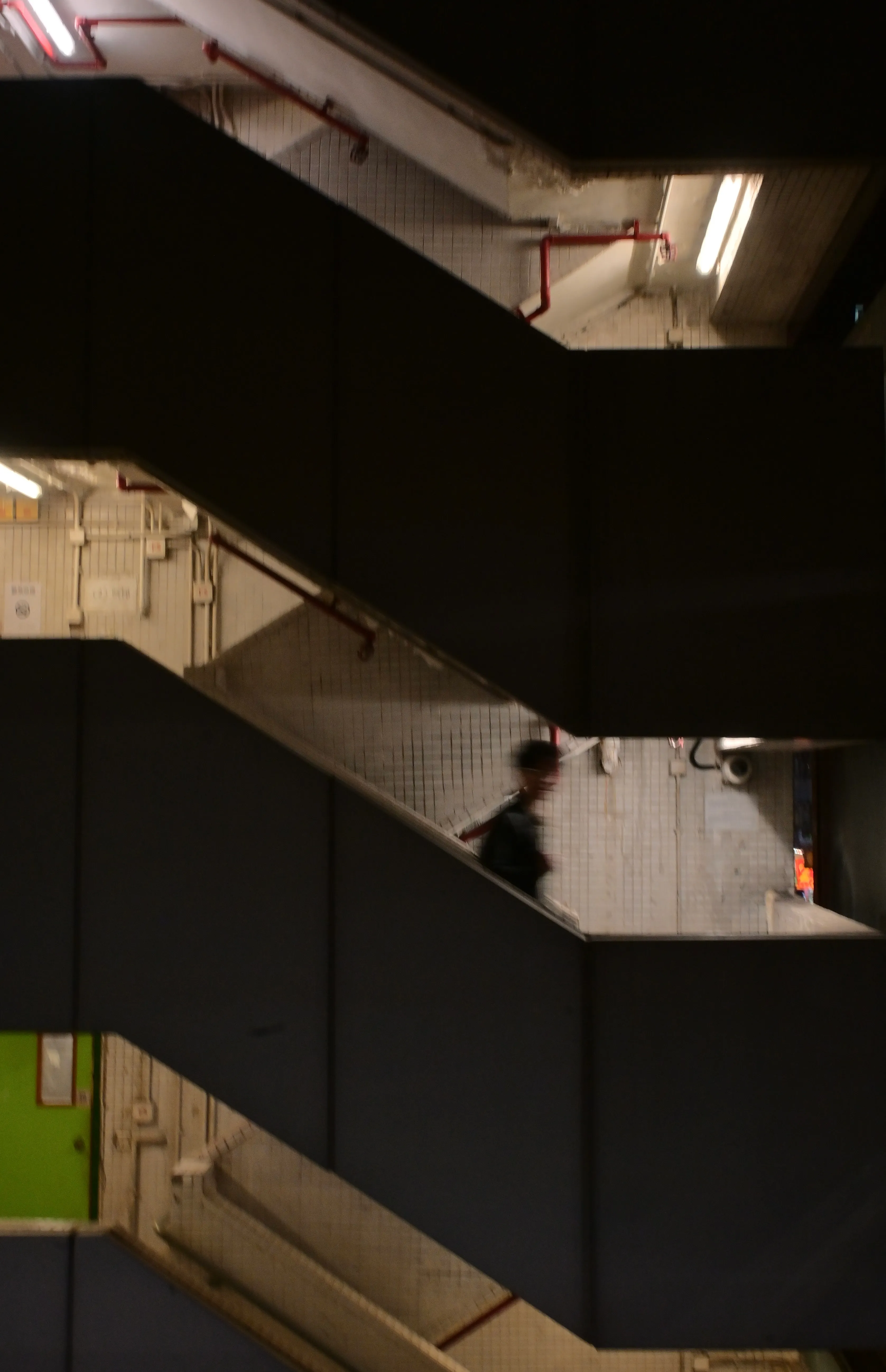 Zigzagging stairwell with a blurred figure descending